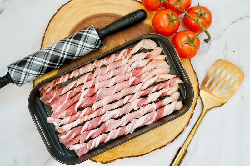 Twisted bacon strips arranged in air fryer basket