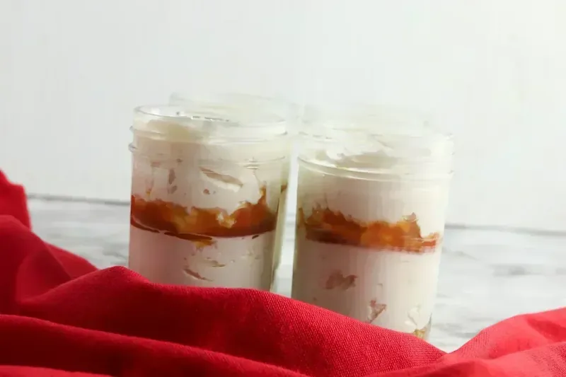 Completed layered cheesecake jars with caramel swirls ready for refrigeration
