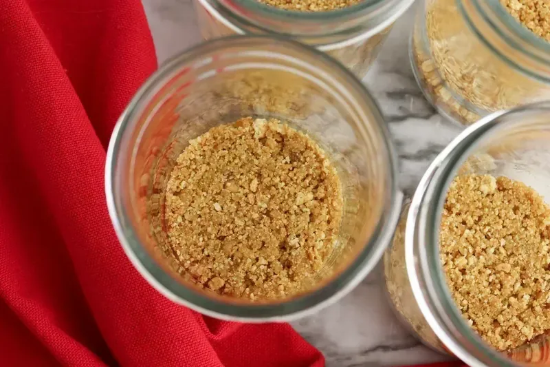 Graham cracker crust pressed into the bottom of glass jars