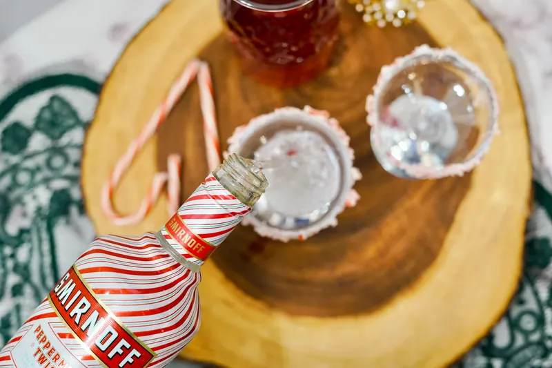 Prepared champagne glasses with candy cane rims ready to be filled with mimosa ingredients