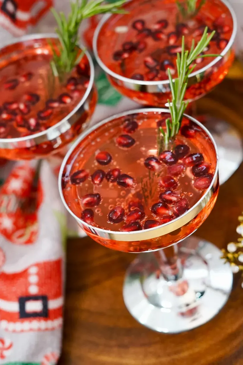 Christmas pomegranate mimosas garnished with fresh rosemary and pomegranate seeds