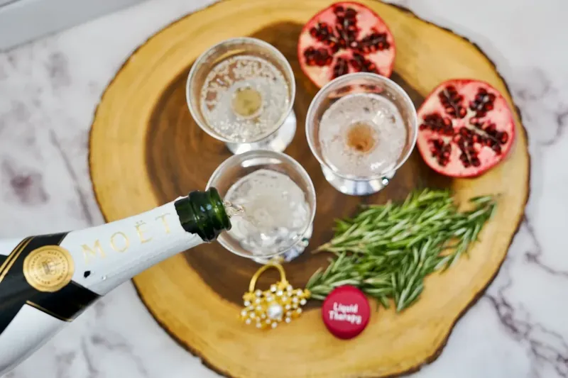 Champagne being poured into glasses for Christmas pomegranate mimosa
