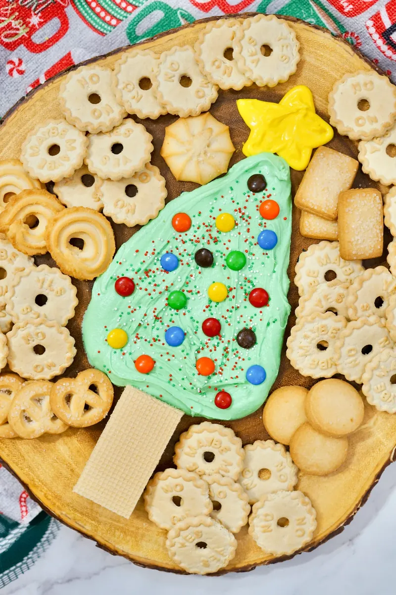 Christmas tree frosting board showing colorful M&M ornaments and variety of dipping cookies
