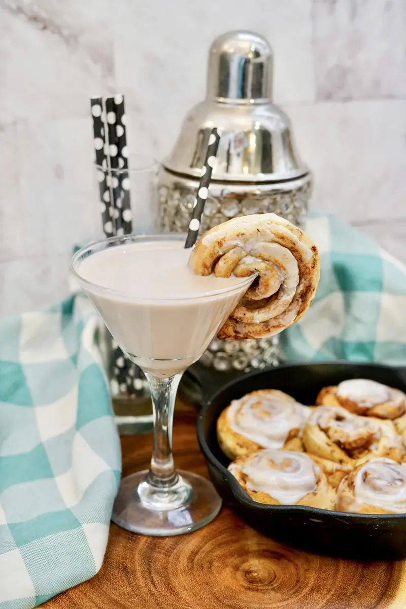 Cinnamon roll martini with cocktail shaker and cinnamon rolls ready for serving