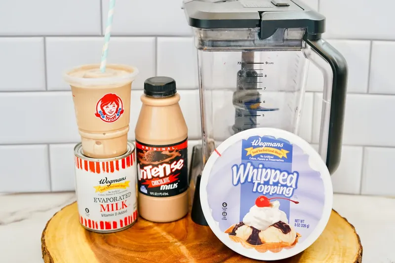 Ingredients for copycat Wendy's Frosty including Cool Whip, chocolate milk, and condensed milk