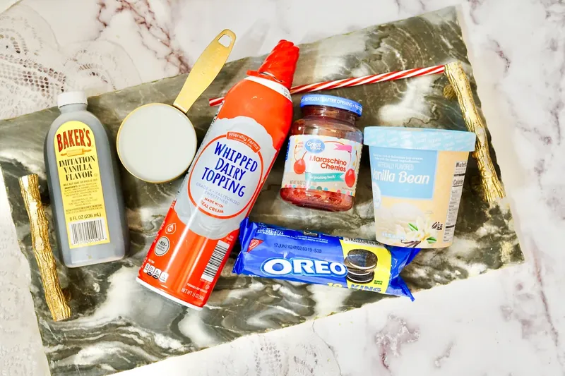 Ingredients for Chick-fil-A copycat milkshake including vanilla ice cream, Oreos, milk, and cherries