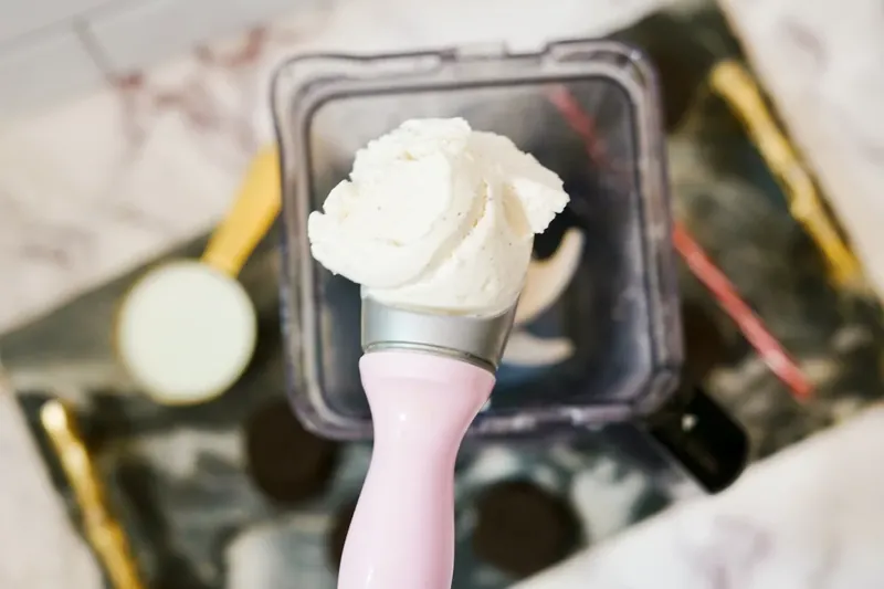Vanilla ice cream being measured into blender for milkshake