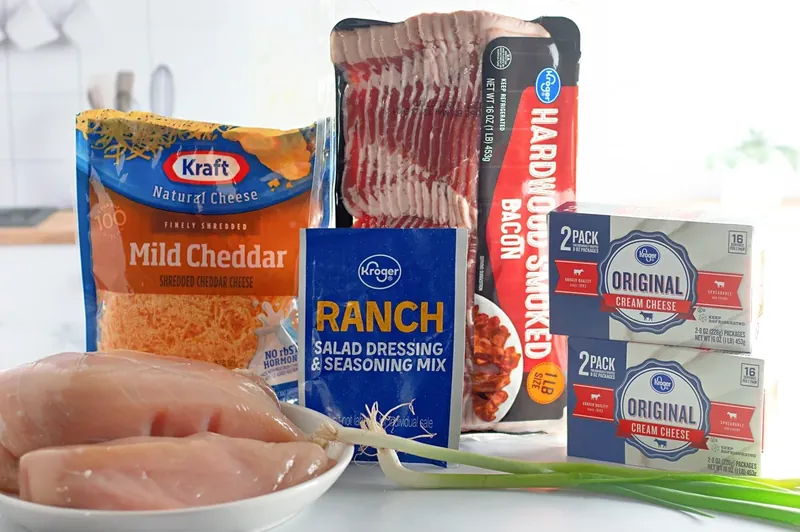Crack chicken ingredients including chicken breasts, bacon, cream cheese, ranch seasoning and cheddar cheese