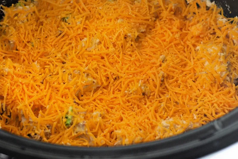Crack chicken topped with melted cheddar cheese in slow cooker