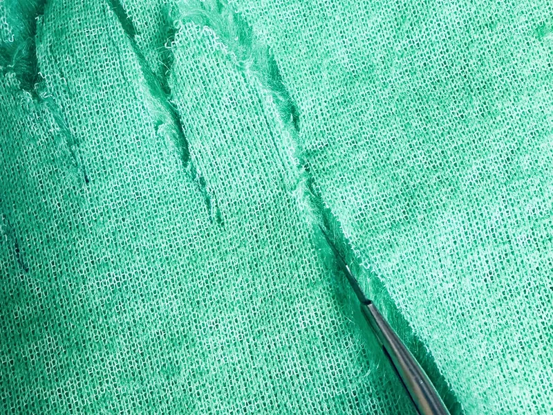 Adding white Santa hat cuff over green fur hand on Grinch wreath to create jacket sleeve