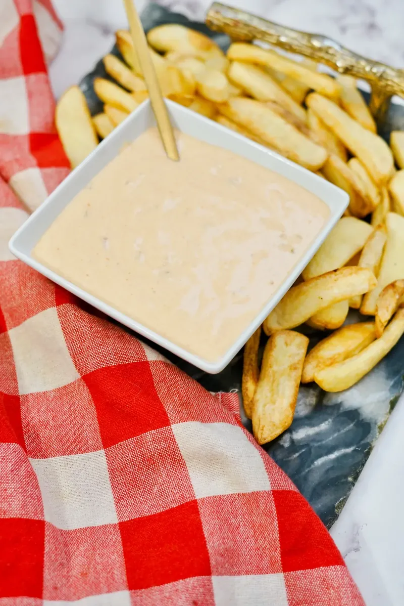 Final presentation of In-N-Out sauce with french fries and red checkered napkin