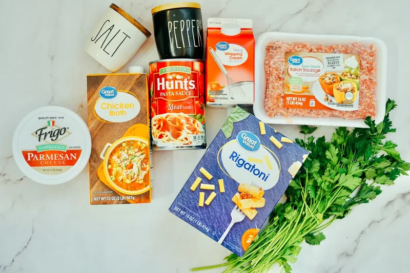 Ingredients for Instant Pot creamy sausage rigatoni laid out on marble counter