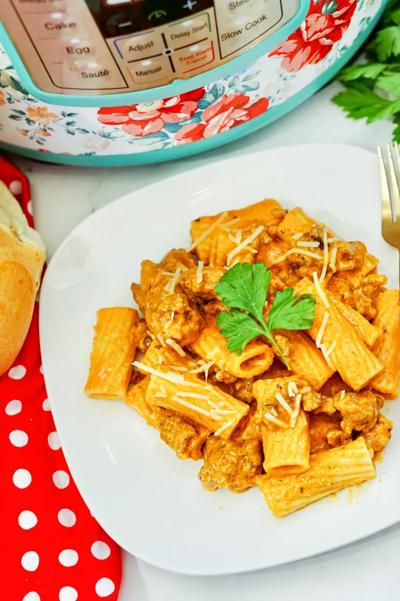 Plated serving of creamy sausage rigatoni with fresh parsley garnish