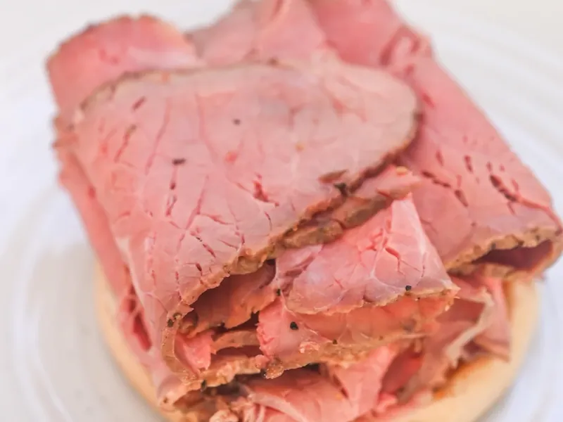 Sliced roast beef layered on keto bun with sauce