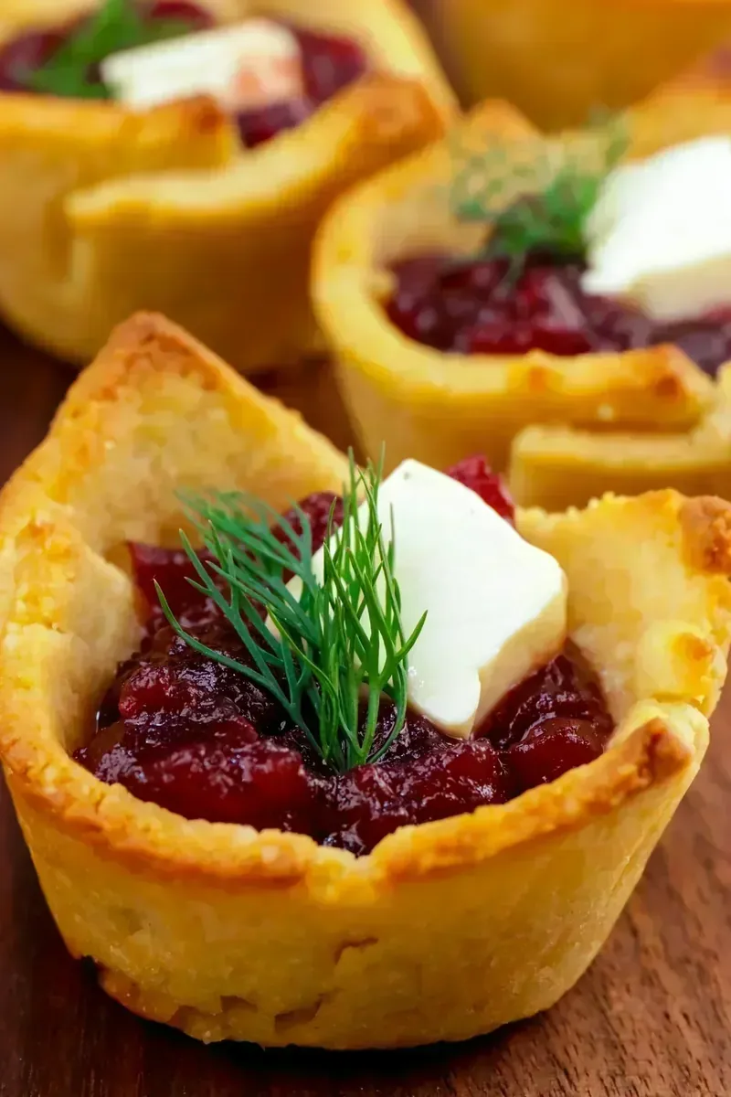 Golden keto pastry cups filled with brie and cranberry sauce