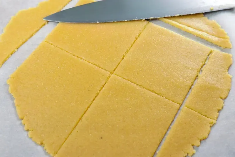 Cutting keto pastry dough into squares with knife