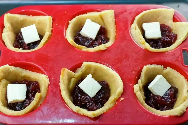 Keto pastry shells filled with brie cheese and cranberry sauce