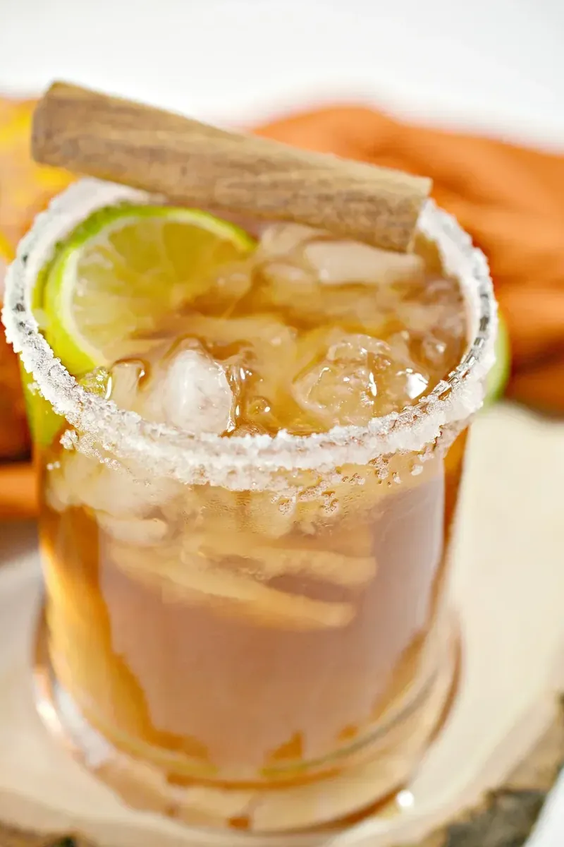 Keto thanksgiving margarita with salted rim, lime wedge and cinnamon stick garnish