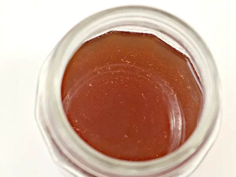 Strained cinnamon apple tea in glass jar showing rich amber color