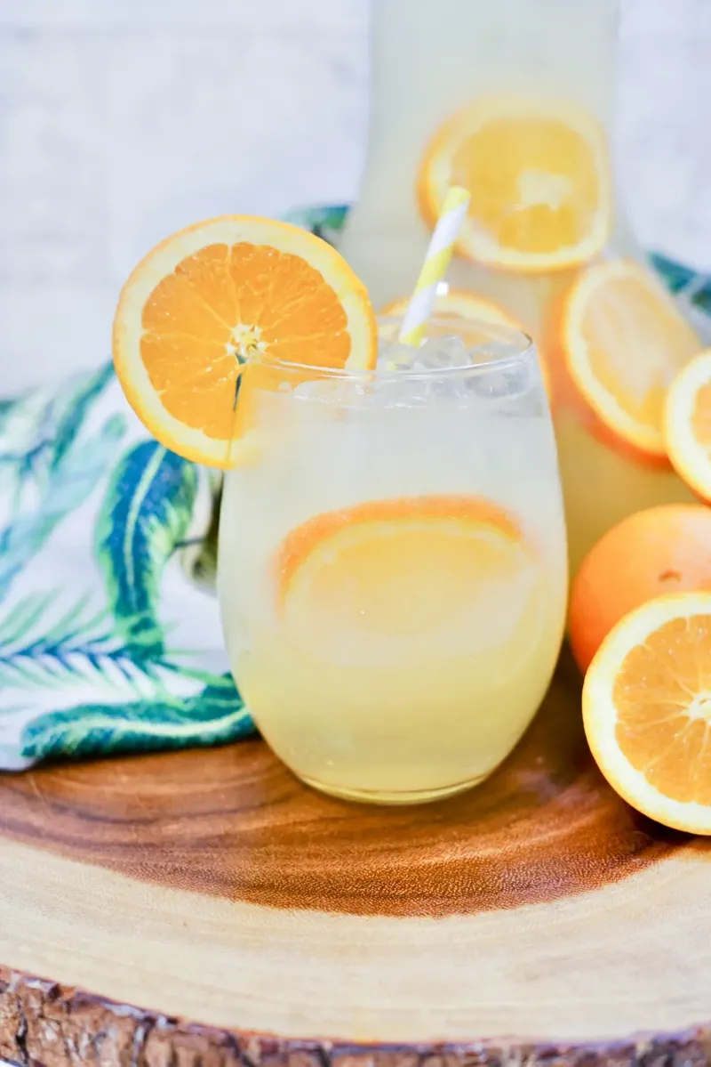 Mimosa sangria in glasses with orange slice garnish and striped straws