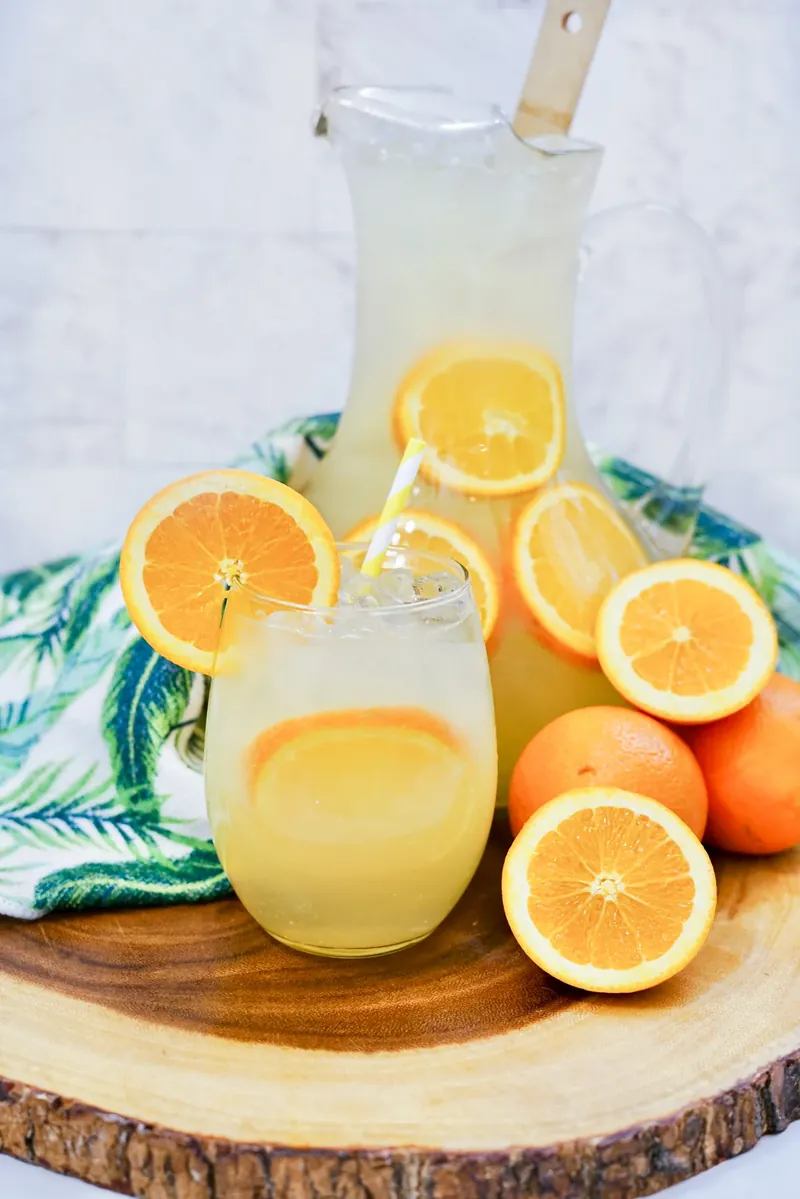 Mimosa sangria pitcher with glasses and fresh orange slices