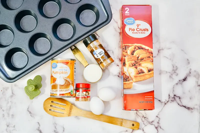 Ingredients for mini pumpkin pies including pie crust, pumpkin puree, spices, and muffin tin