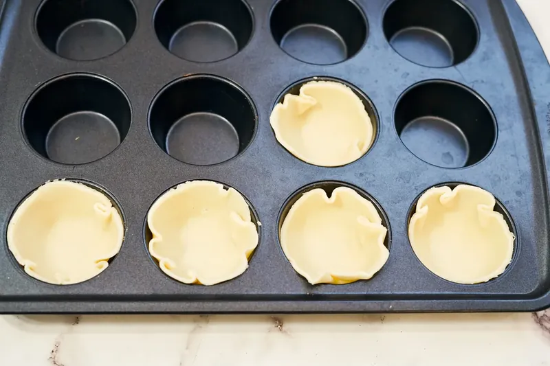 Pie crust circles pressed into muffin tin cups