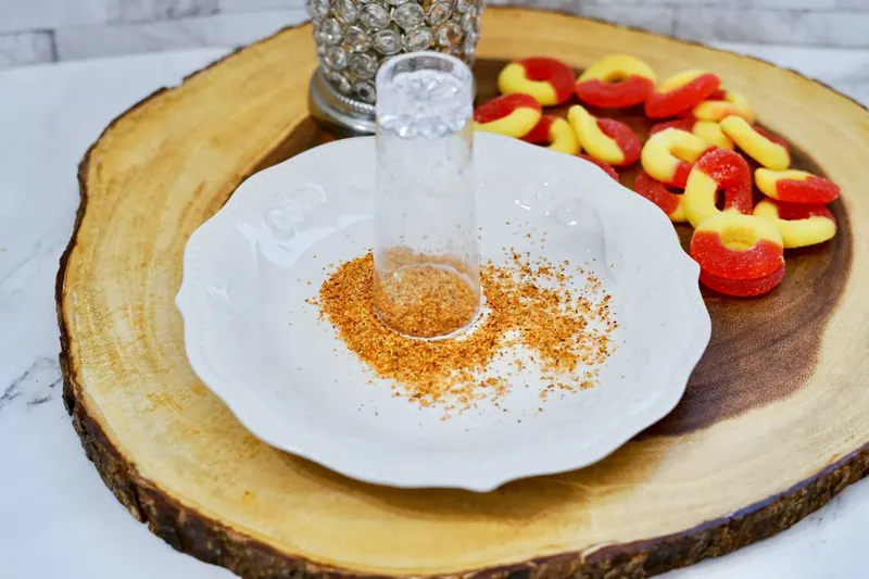 Pouring peach juice into shaker to make peach margarita shooters