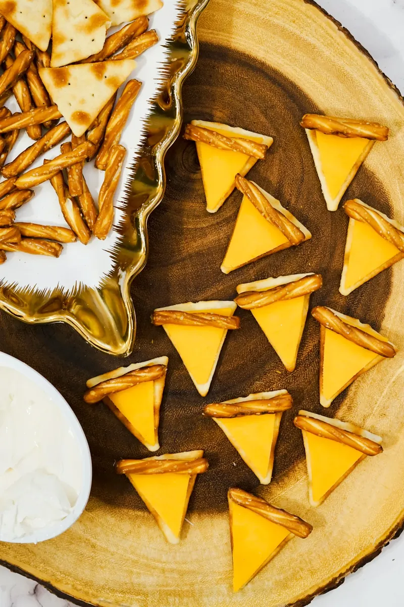 Close up of pie cheese crackers showing cheese triangles and pretzel stick crusts