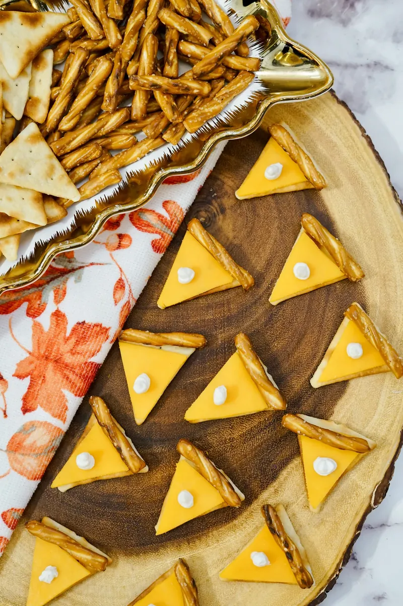 Pie-shaped cheese crackers with pretzel crusts and cream cheese dots