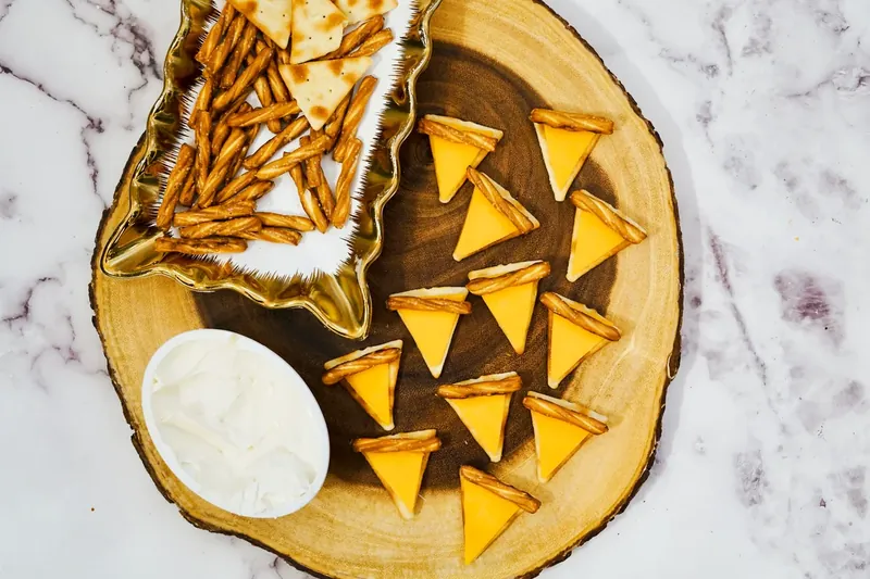 Adding pretzel stick pieces to create pie crust effect on cheese crackers