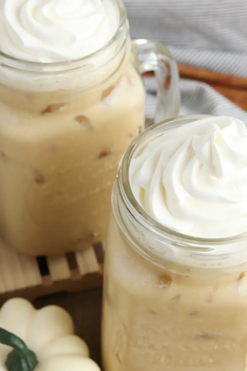 Pumpkin sweet cream cold brew styled with mini pumpkins for fall