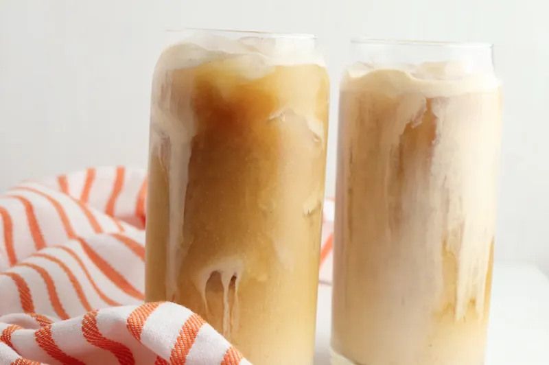 Two completed pumpkin sweet cream cold brew drinks with layered cream