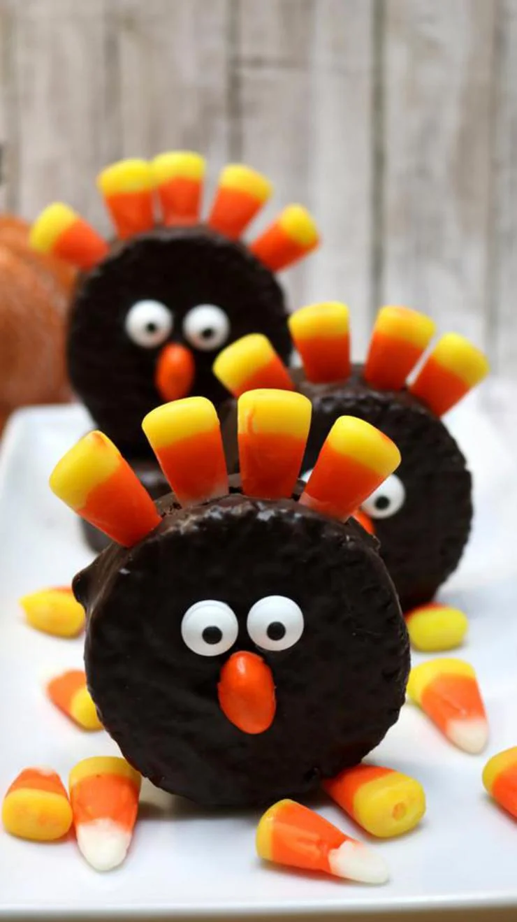 Stacked Oreo cookies decorated as turkeys with candy corn feathers and googly eyes