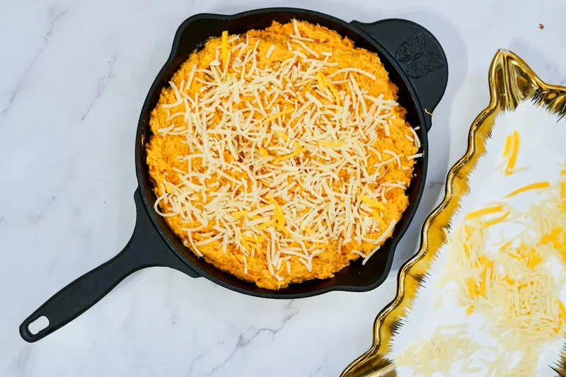 Cast iron skillet filled with chicken dip mixture topped with mozzarella cheese