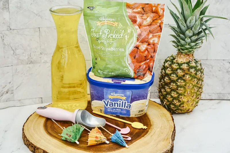 Ingredients for strawberry dole whip including pineapple juice, frozen strawberries, vanilla ice cream and pineapple