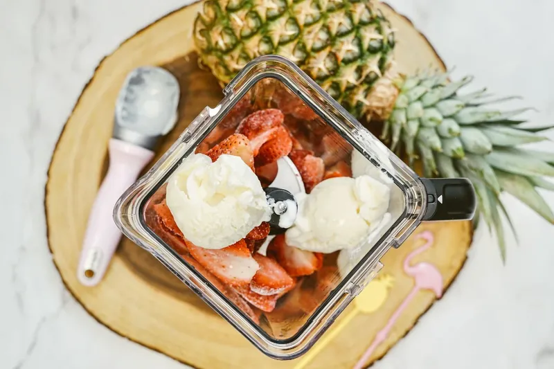 Blended strawberry dole whip mixture in blender showing smooth pink texture