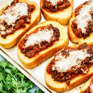 Texas toast sloppy joes with melted mozzarella cheese on baking sheet