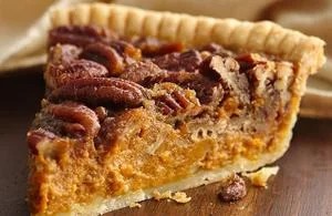 slice of classic pecan pie with golden crust and caramelized pecan topping on wooden surface