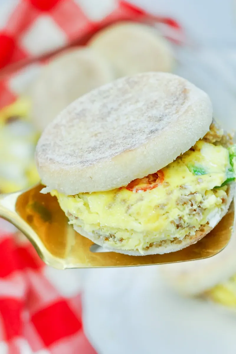 Close-up of golden breakfast sandwich with visible vegetables and sausage