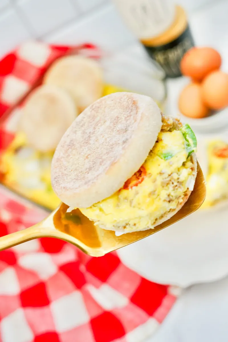 Hand holding completed breakfast sandwich showing layers and fillings