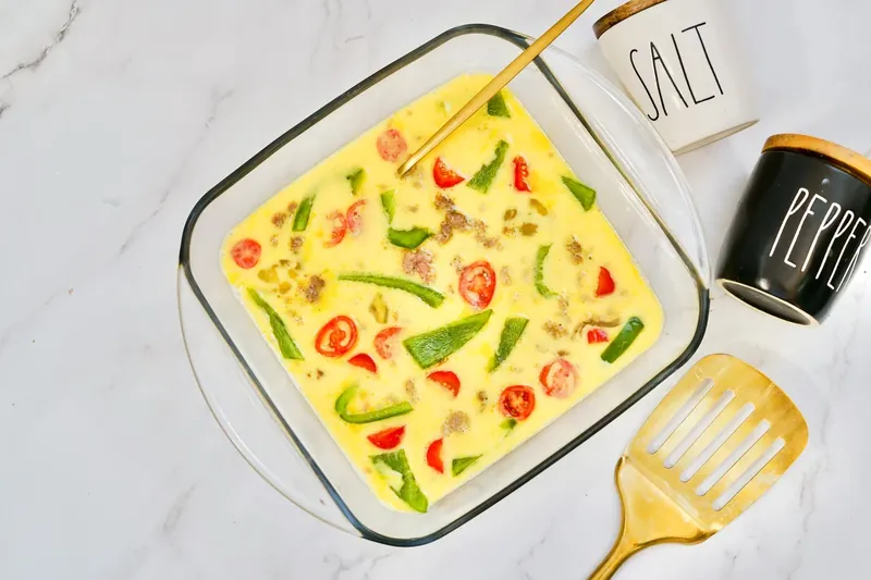 Complete breakfast sandwich mixture ready to bake in glass dish