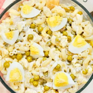 Finished tuna mac salad in bowl with wooden spoon, showing creamy texture