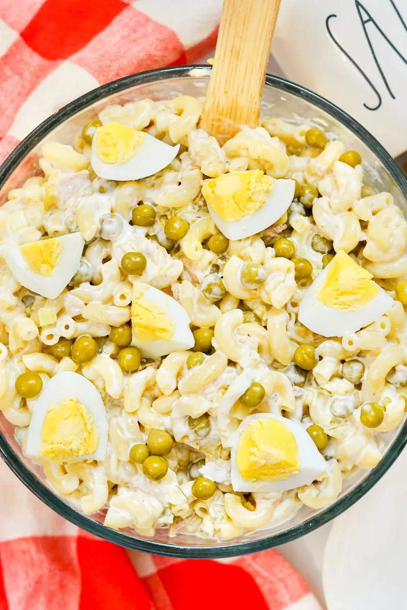 Finished tuna mac salad in bowl with wooden spoon, showing creamy texture
