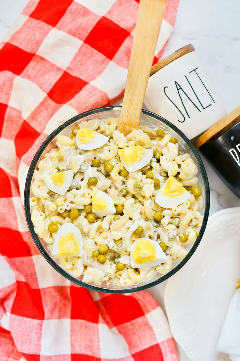 Overhead view of tuna mac salad bowl with red checkered napkin
