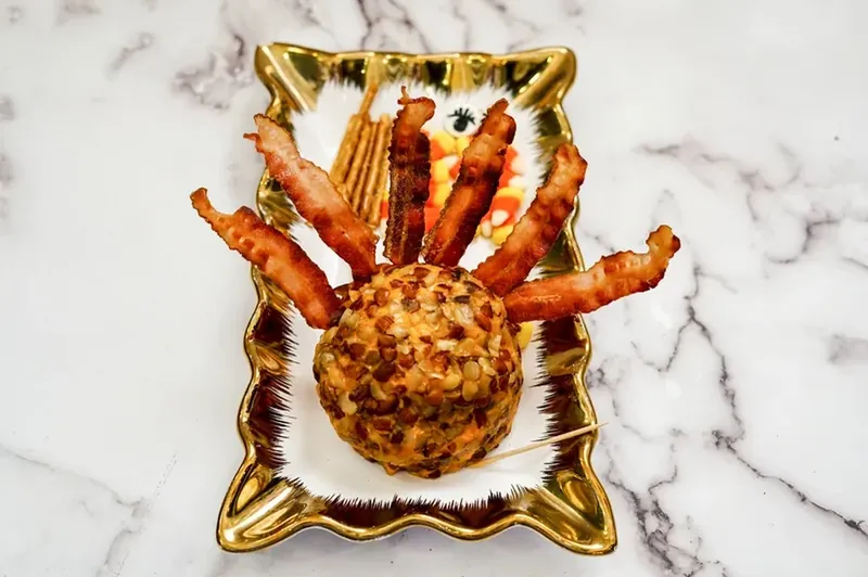 Turkey cheese ball with bacon strips inserted as feathers
