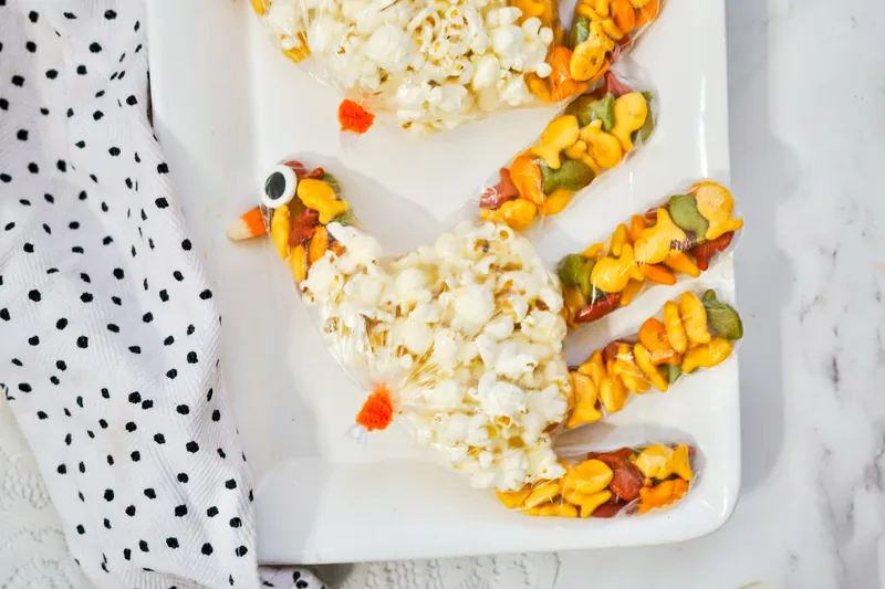 Turkey treat bags filled with colorful snacks and popcorn bodies with googly eyes for Thanksgiving