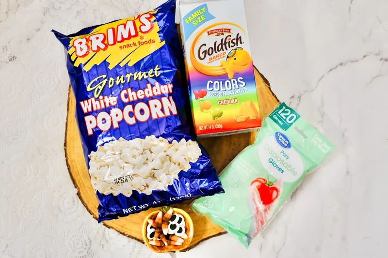 Ingredients for turkey treat bags including popcorn, goldfish crackers, plastic gloves, and decorations