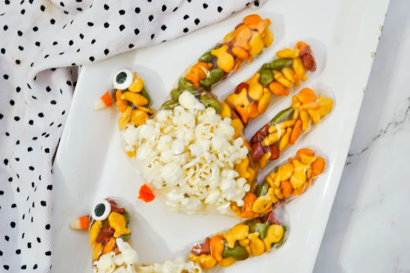 Completed turkey treat bags with goldfish feathers, popcorn bodies, and candy decorations