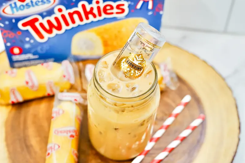 Mini vanilla vodka bottle being added to Twinkie iced latte drink